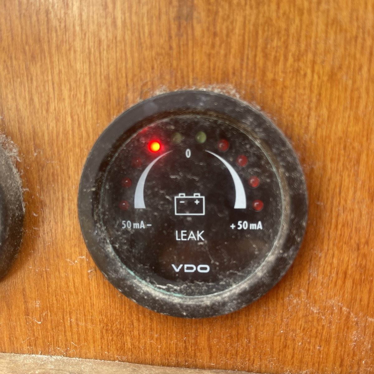 The original VDO leak tester: a dusty LEAK dial graduated from -50 mA to +50 mA, with a red LED lit on the negative side